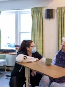 A health care worker talking to a resident in a care facility