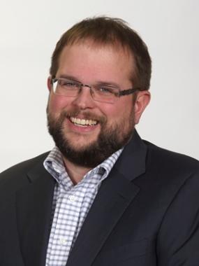 Portrait of Angus Bonnyman, Employer Representative, Smiling in a black blazer.