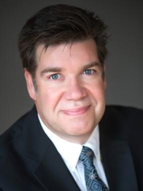 Headshot of Steve Ashton, Employer Representative, in a black suit and blue tie.